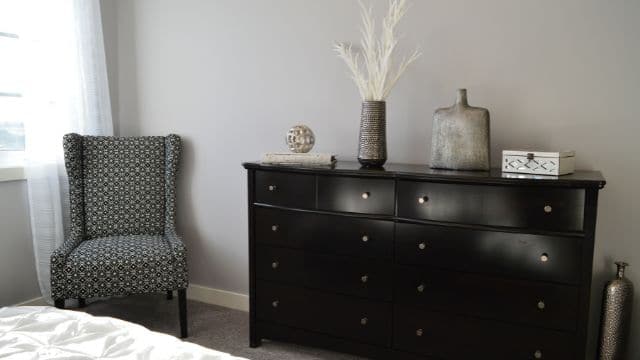 Black Wood Dressers and Patterned Chairs